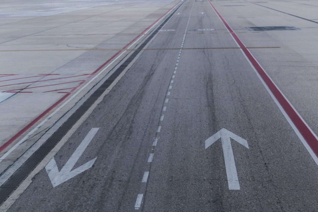Arrow signs on road. taxiway for airplanes and tracks for road transport. Airport. Travel concept
