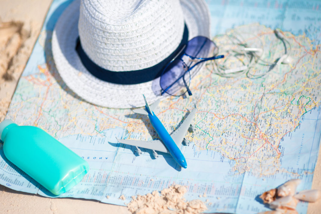 Passport, ticket, phone on a background map of the world. Traveling concept